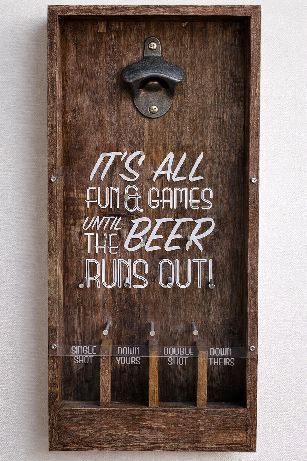 Close-up of wooden bottle opener beer game showing printed drinking game text and hooks