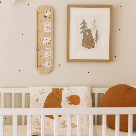 Nursery room with crib, growth chart, and framed picture of a bear and trees.