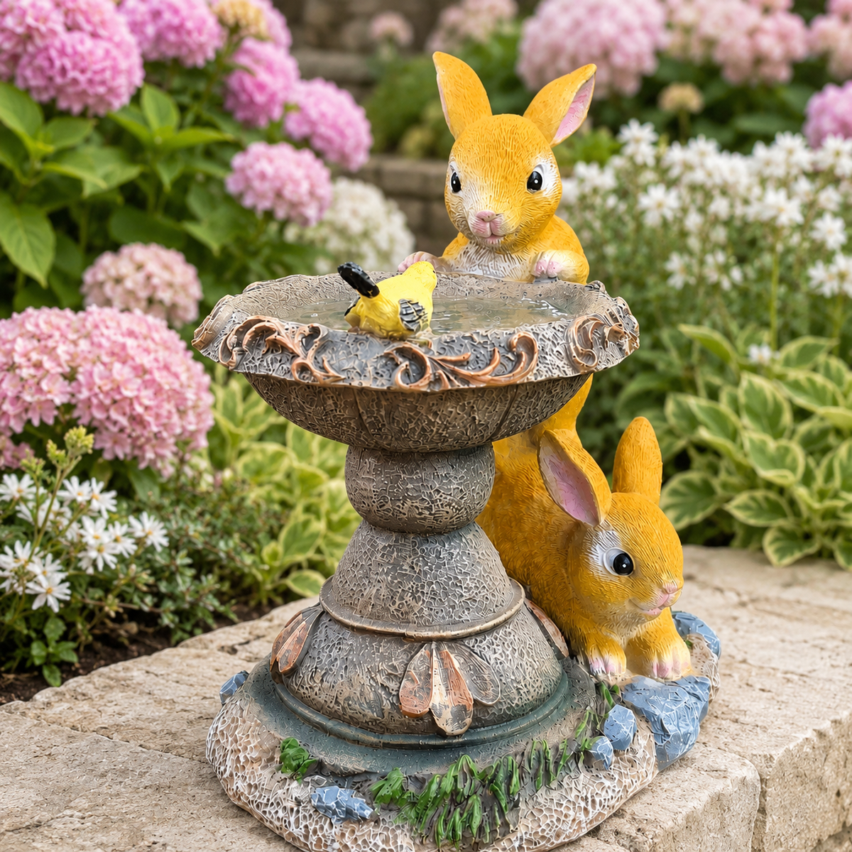 Solar rabbit bird bath ornament beside pink hydrangeas