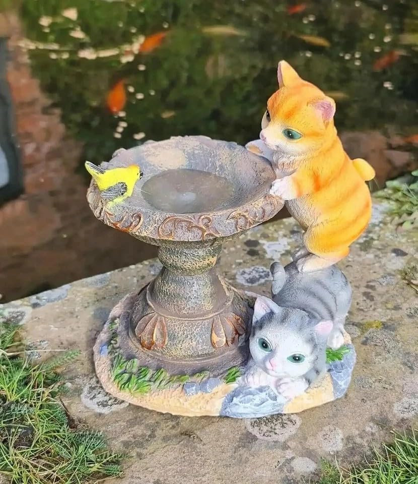 Solar cat bird bath ornament in a garden border