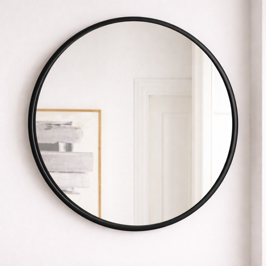 Round black-framed mirror on a white wall