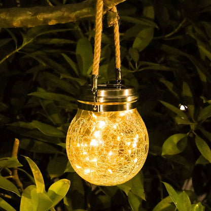 Solar-powered hanging light with crinkled glass design in a natural setting