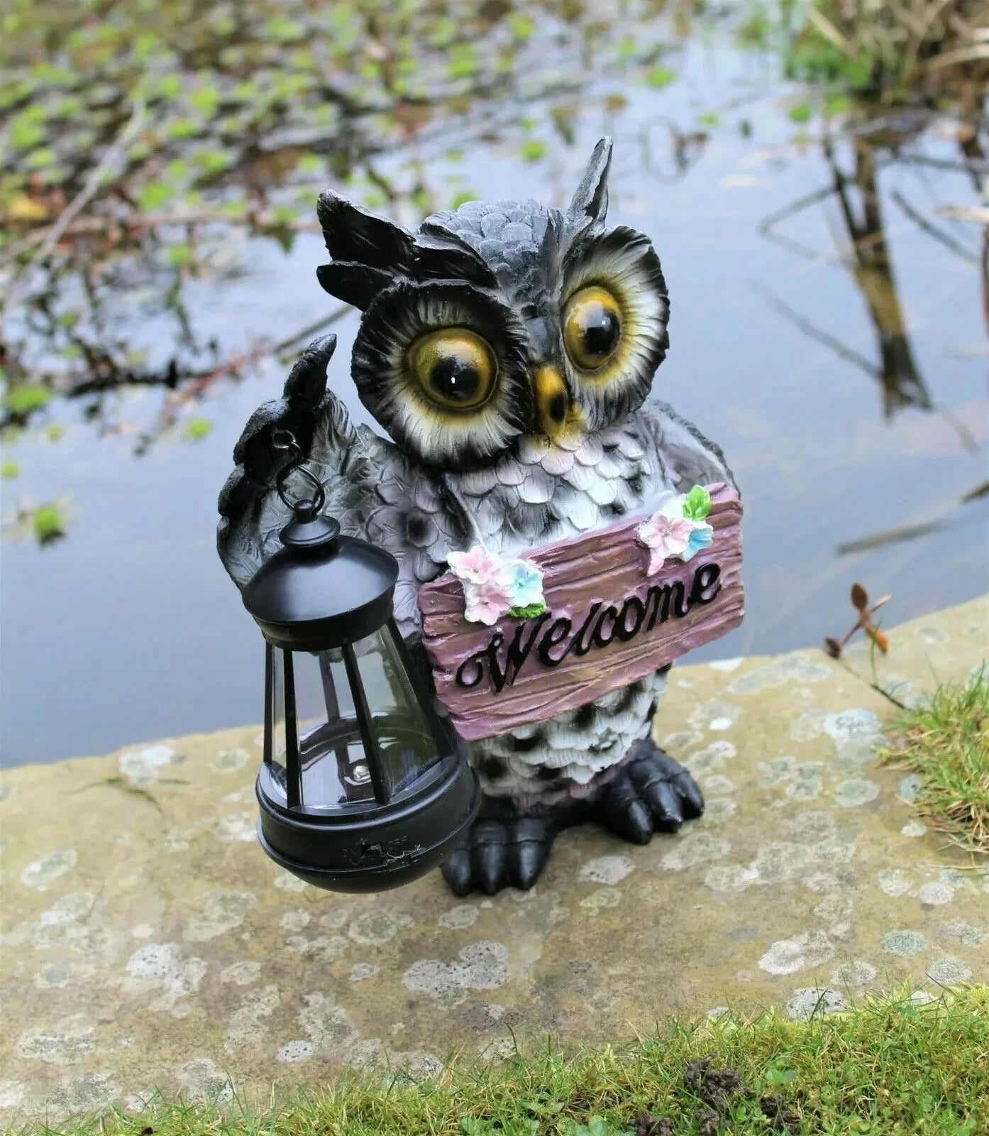 Solar owl ornament glowing at night in garden